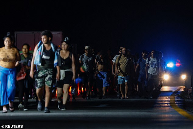 Migrants walk in a caravan along a highway on their way to the border with the United States, in Saltillito, Mexico, on November 7.