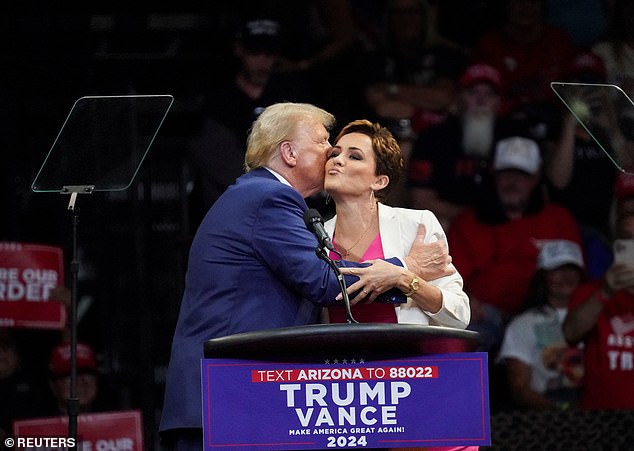 Trump and Lake hug and kiss each other on the cheek while campaigning together at a rally in Prescott Valley, Arizona, on October 13, 2024.