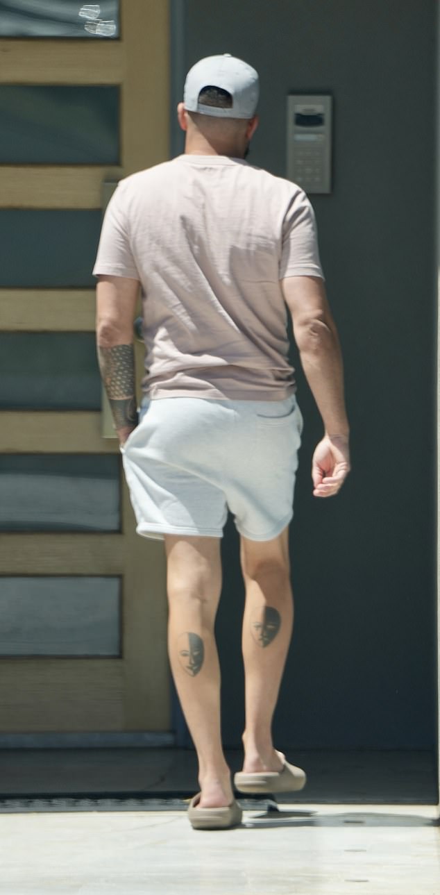 The businessman showed off his tattoos when he was seen entering his luxurious home, complementing his casual look with a cap and flip-flops.