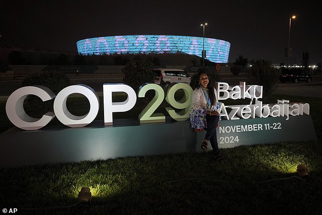 The prime minister is one of the only prime ministers from Azerbaijan's wealthiest nations to attend the annual meeting. In the photo, an attendee poses with the COP29 poster.