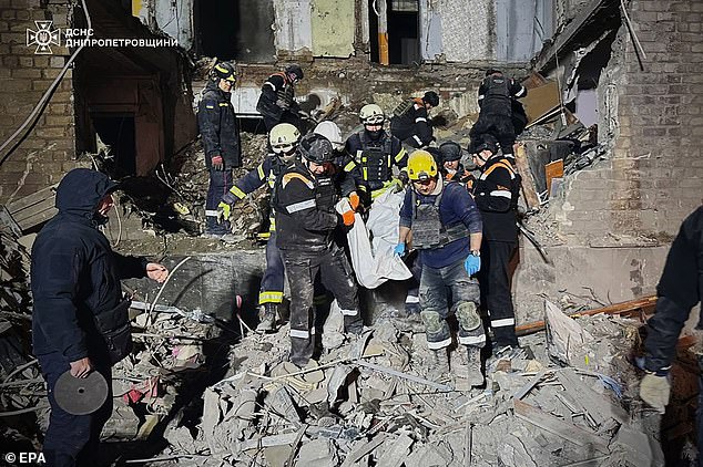 A photo provided by Ukraine's State Emergency Service on Nov. 12, 2024, shows Ukrainian rescuers carrying the body of a woman at the site of a glider bomb attack on a residential building in Zaporizhzhia, Ukraine, Nov. 11, 2024. 2024.