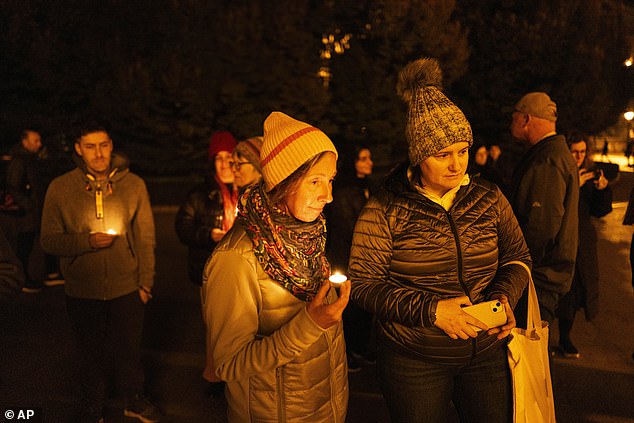 Friends hold candles as they remember Michalski during a candlelight vigil in Budapest, Hungary, on Saturday, Nov. 9.