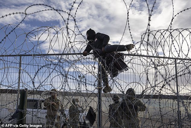 A Venezuelan migrant jumps a border fence in an attempt to enter and request asylum in El Paso, Texas, from Ciudad Juárez, Chihuahua, Mexico, on April 2, 2024.