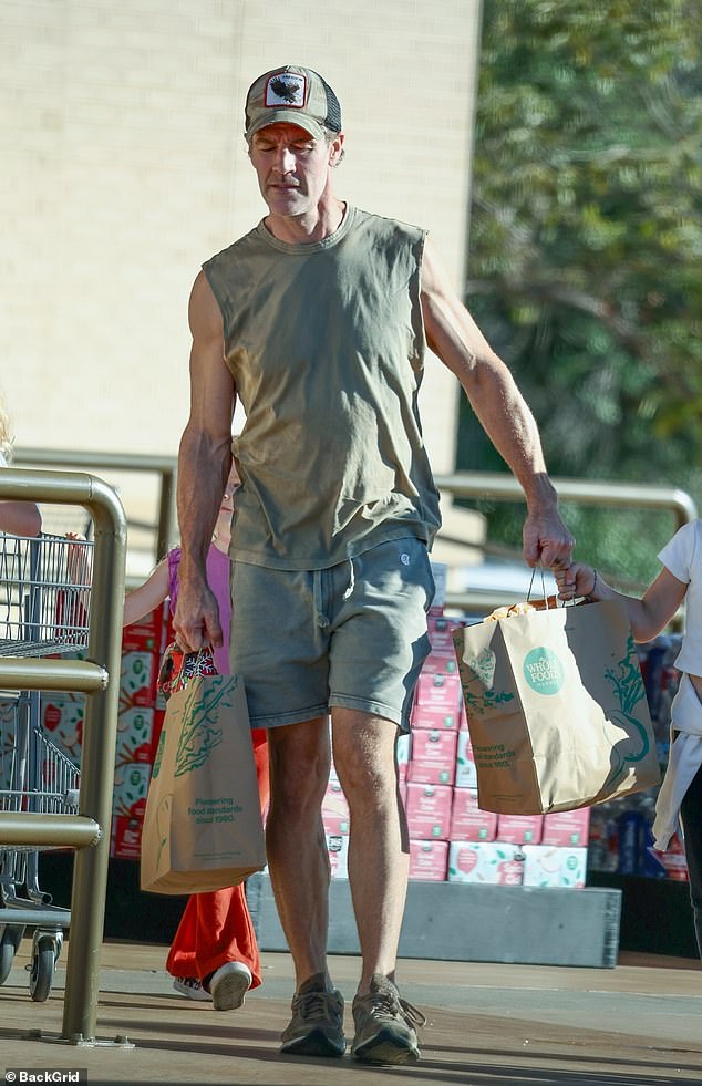 The actor left the store with two grocery bags and his daughter adorably helped him carry his purchases while grabbing one of the handles.