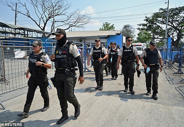 Police officers walk outside the Litoral Penitentiary, where at least 15 inmates were killed Tuesday after a fight in one of the prison buildings.