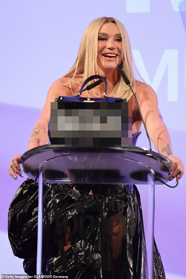 She picked up the Music Icon award winner on stage and as she walked she carried a large black leather bag that said 'bitch' on it.