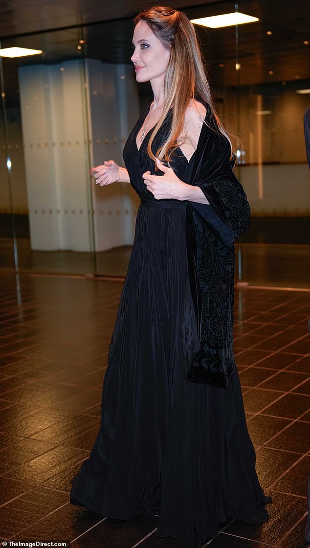 Jolie turned heads in a flowy black dress that featured a plunging neckline in the front and a fitted waist.