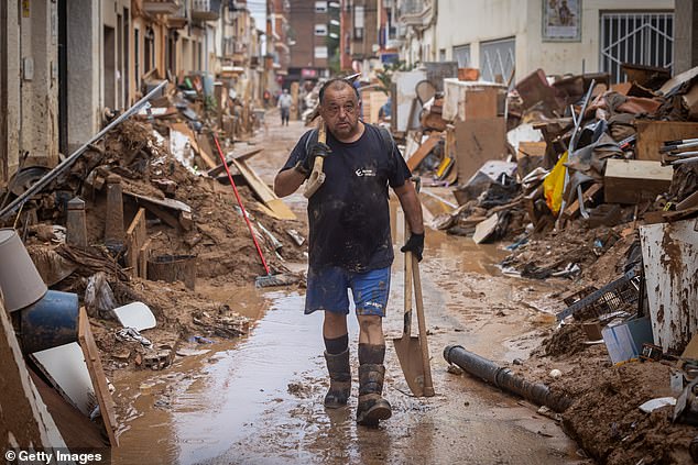 A man cleans his house after heavy rain and flooding hit much of the country on November 4, 2024 in Paiporta, Spain.