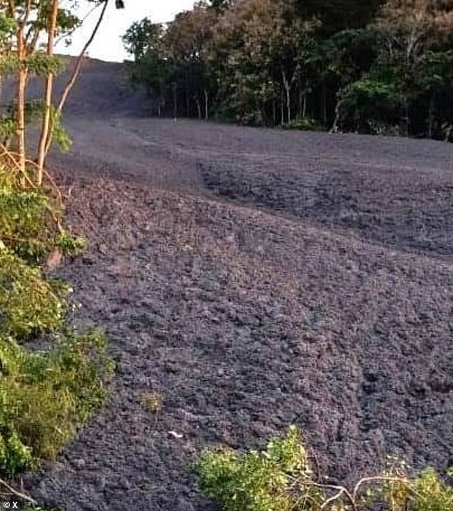 Mud covers the path of a road near the volcano after its eruption on Monday