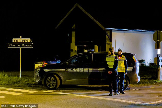 French gendarmes stand guard at the street entrance near the place where three children were found dead in Taninges, November 12, 2024.