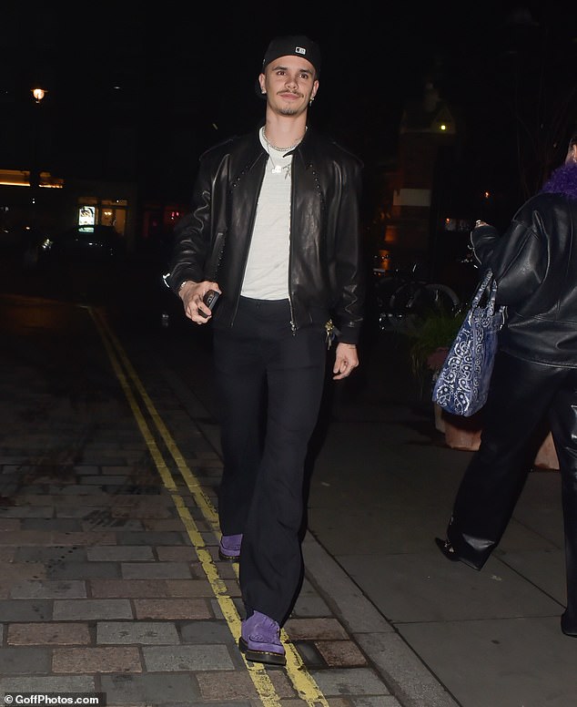 The son of David and Victoria Beckham opted for a striking pair of purple shoes, wore a black hat and layered several silver necklaces.