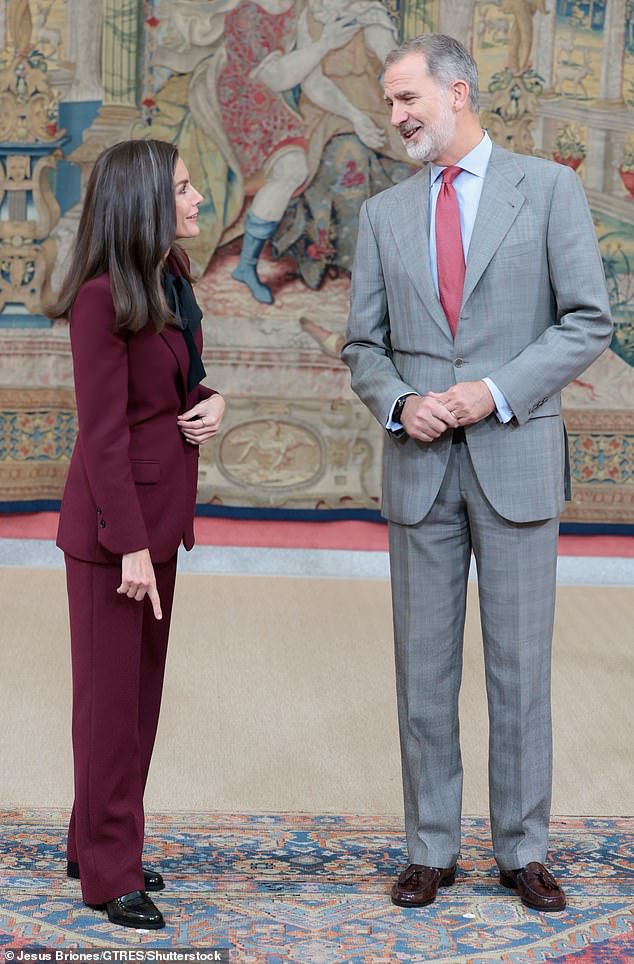 King Philip, 56, looked dapper in a gray checkered suit which he paired with a crisp blue shirt, red patterned tie and shiny brown loafers.