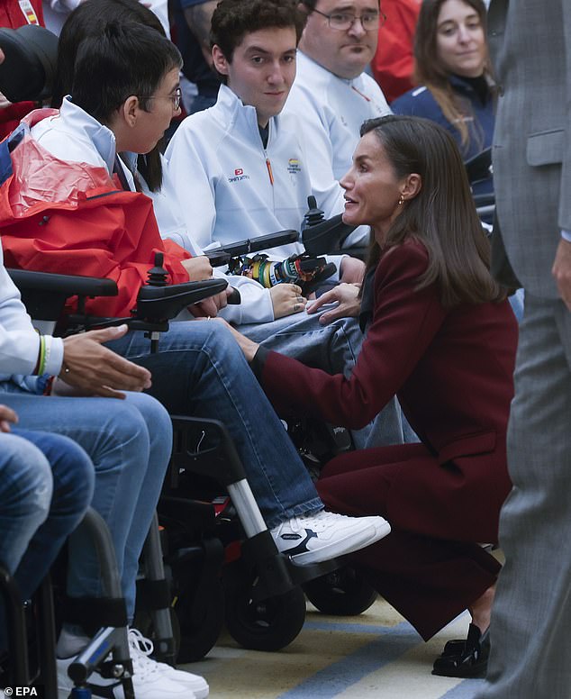 Letizia crouched down to talk to a Paralympian during today's event in Madrid