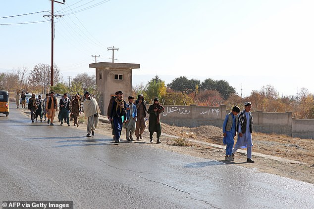 Afghans walk towards a football stadium before the public execution of a man by the Taliban in Gardez, Paktia province, on November 13, 2024.