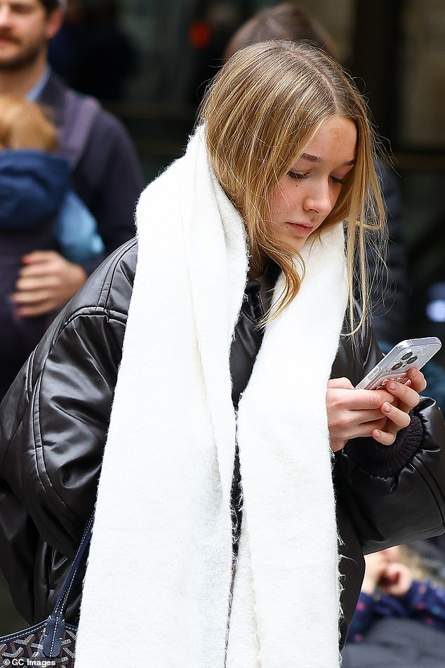 Harper cut a casual figure in a brown leather jacket and navy blue jeans, paired with a thick white scarf.