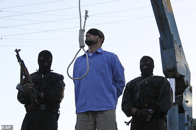 A blindfolded man convicted of armed robbery, kidnapping and murder of two police officers waits to be hanged in public in Tehran, Iran, April 16, 2011.