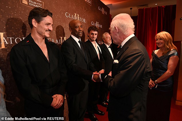 The couple smiled and shook hands before King Charles III congratulated Denzel: 