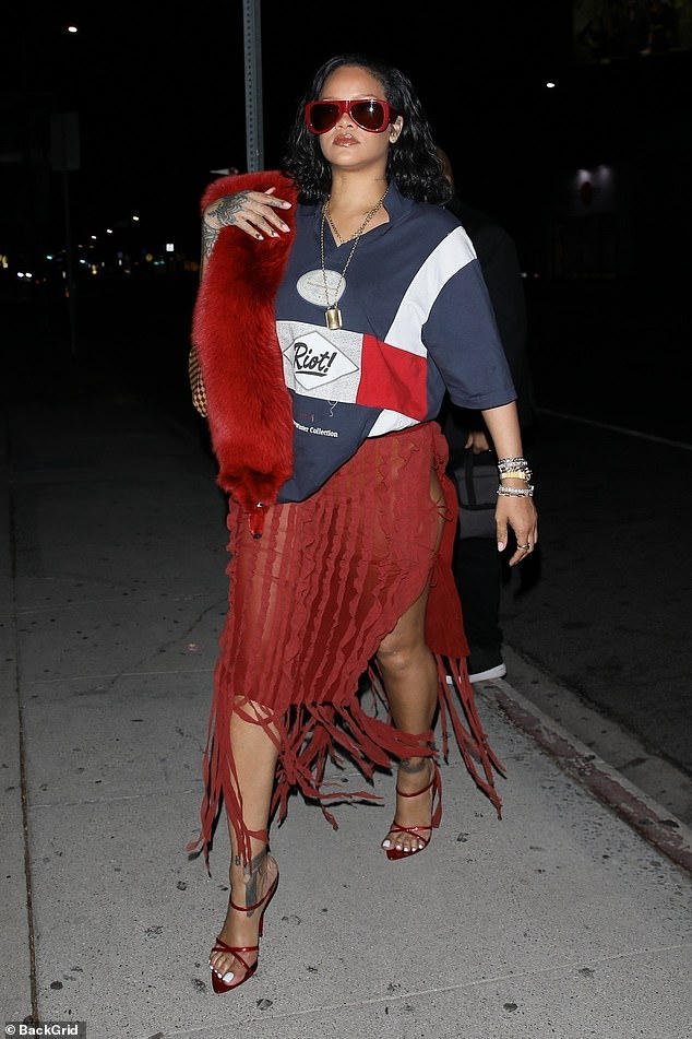 For a glamorous touch, Rihanna wore a red fur shawl over one shoulder and skipped down the sidewalk in sky-high heels.