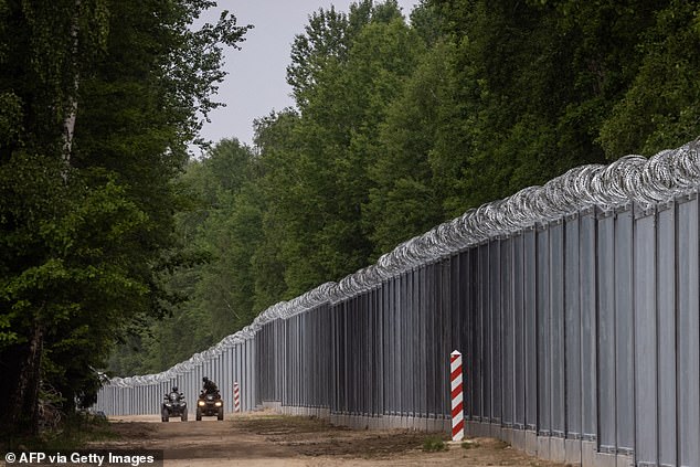 Border guards patrol on quad bikes along the border wall on the Polish-Belarusian border near the village of Tolcze in northeastern Poland on June 8, 2022.