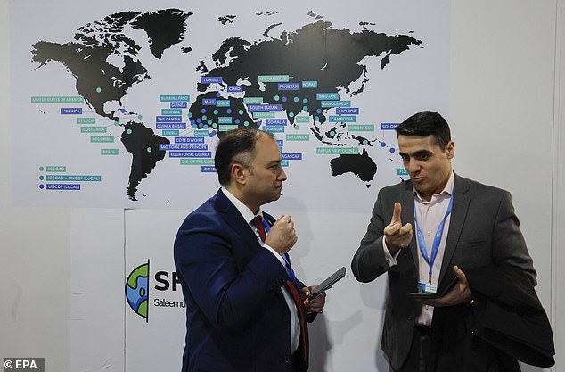 Participants chat while visiting an exhibition at the United Nations Climate Change Conference COP29 in Baku