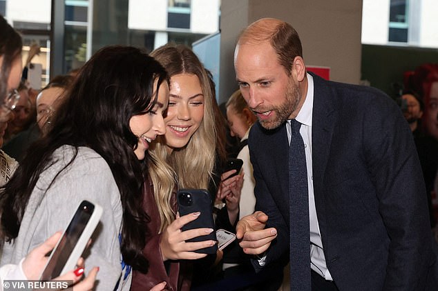 The royal was all smiles as she helped a student record a video message for a friend on her phone today.