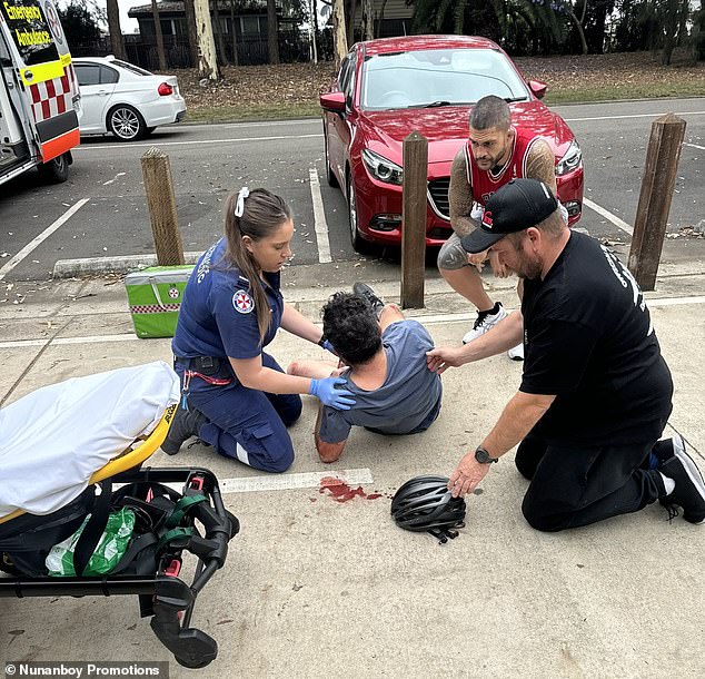 Pedro (above right) watches as paramedics help the man, who was left bleeding after falling from his bicycle during the health emergency.