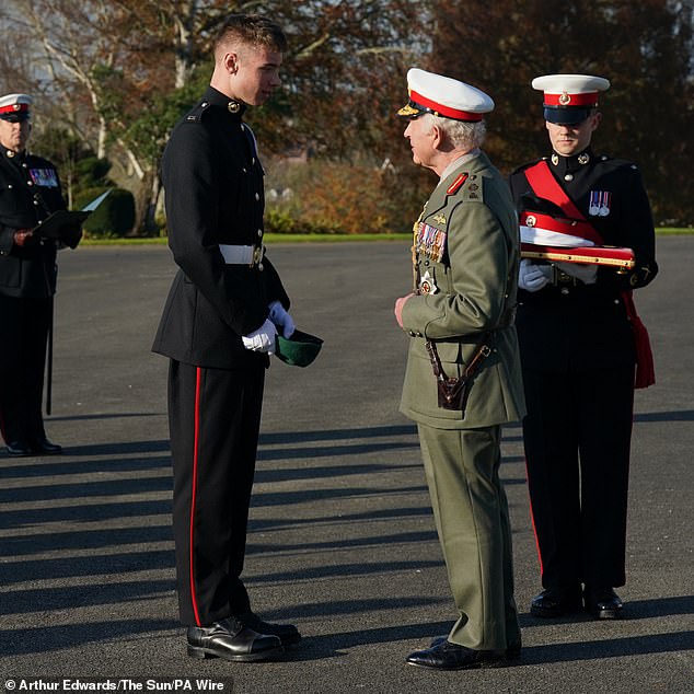 The King awards Marine Joseph Ryan the Commando Medal during a visit to the Royal Marines Commando Training Center