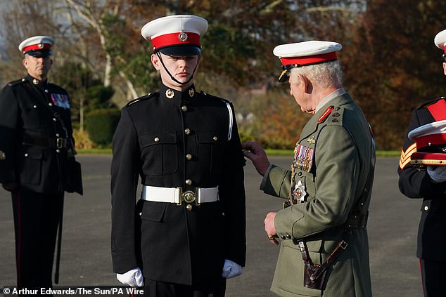 King Charles III, as Captain General of the Royal Marines, awards sailor Osian Stephens the King's Badge