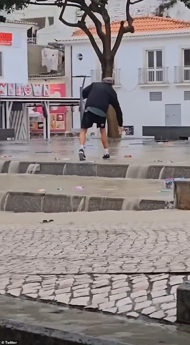 In the photo, a man walks through flash floods in Albufeira, Portugal.