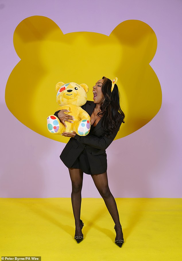 Influencer Ash Holme wowed in a low-cut black blazer, stockings and heels as she hugged Pudsey.