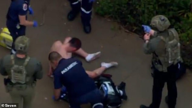 A shirtless man is treated by paramedics at the scene in Weir Views, Melbourne.