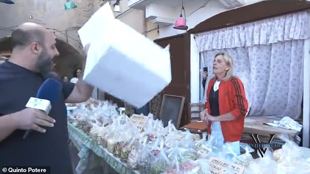 Loconte shakes a box at a pasta seller, stating that his products are mass produced and not at home.