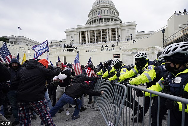 Insurrectionists loyal to President Donald Trump try to break through a police barrier, on January 6, 2021, at the Capitol in Washington.