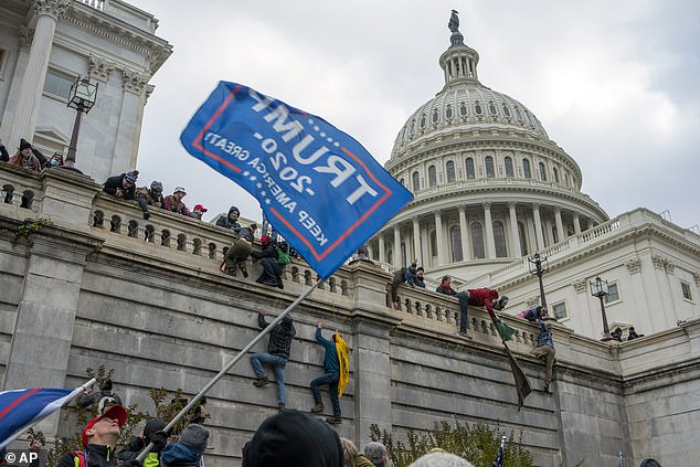 Supporters of President Donald Trump climb the west wall of the U.S. Capitol on Jan. 6, 2021, in Washington.