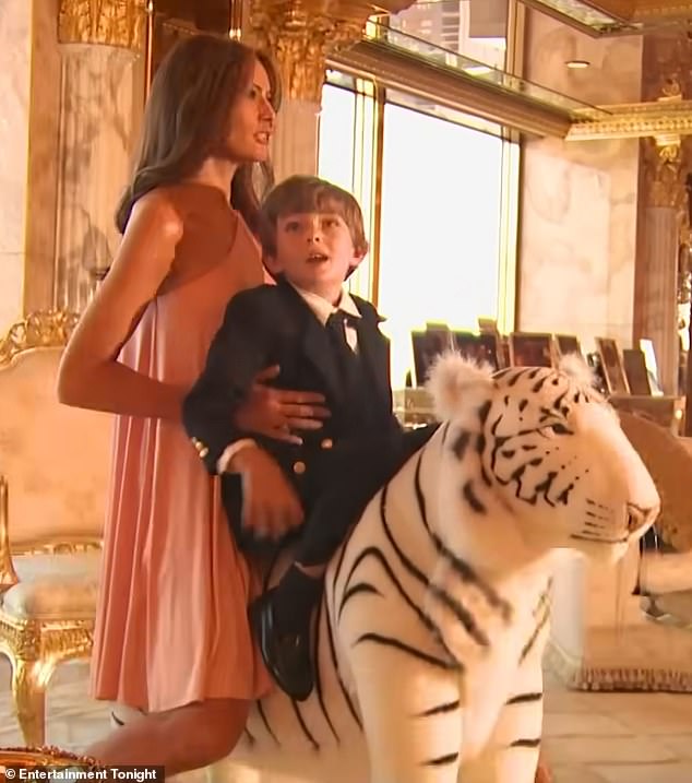 Melania and Barron are seen posing together on a large white stuffed tiger as part of a photo shoot.