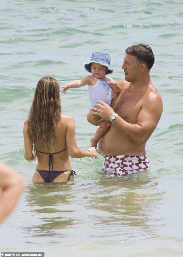 The one-year-old seemed to be having fun on the beach while mom and dad obediently pampered her.