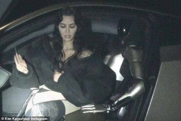 The Kardashians star, 44, went topless under a puffy black jacket and sat on the robot's lap as they posed in the driver's seat of her custom Tesla Model S car