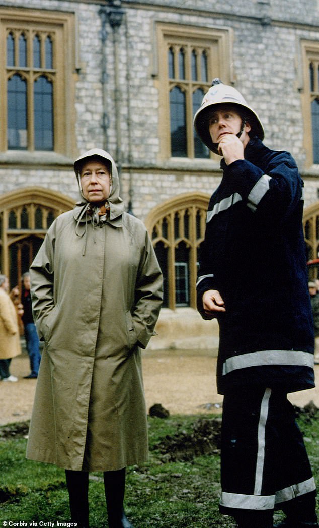 Queen Elizabeth assesses the damage with a firefighter