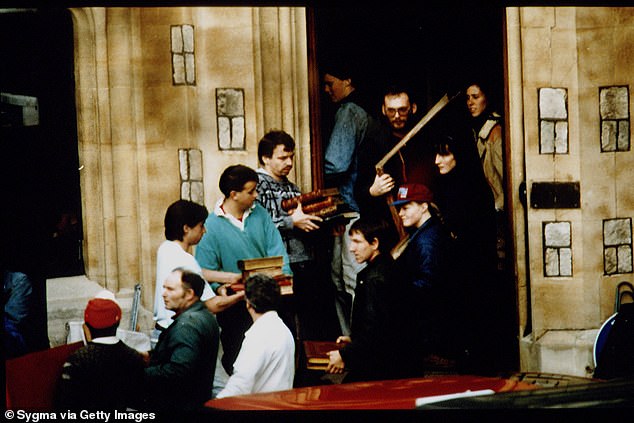 People form a chain to help remove books and artwork from the castle as the fire continues.