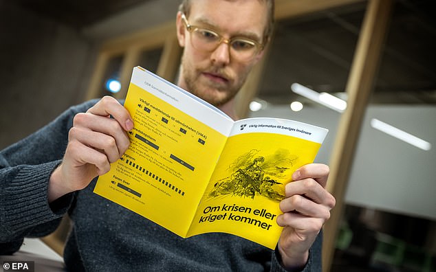 A man poses with the 2024 version of the brochure 'If Crisis or War Comes' in Stockholm