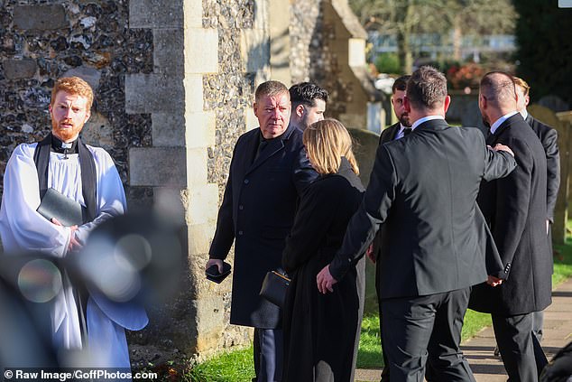 Liam Payne's father, Geoff, and mother, Karen, stand outside the church before today's funeral.