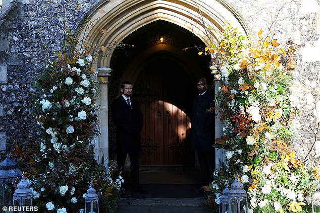 People meet at the door of a church before the funeral.