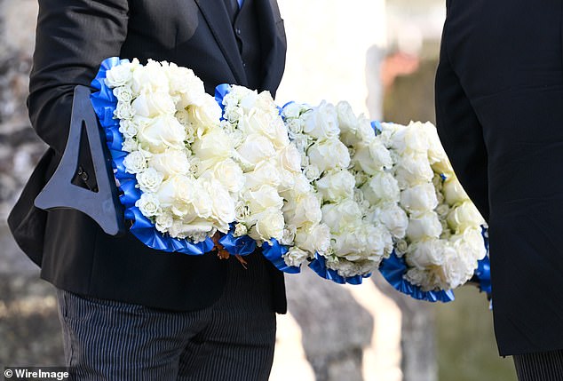 A floral tribute that spells the word. "Dad" at the funeral