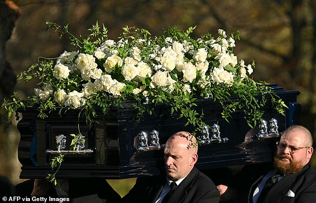 Payne's coffin is carried out of the church by pallbearers after today's service.