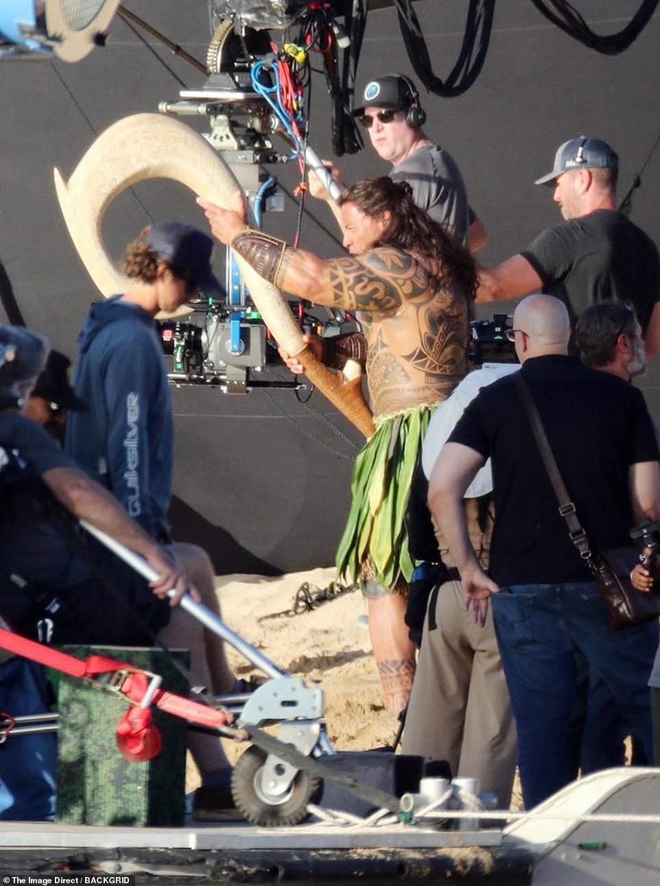 Johnson was seen with Maui's iconic magical fishing hook on set