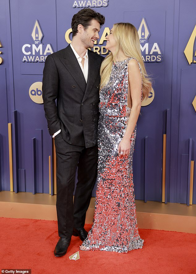 The 31-year-old country sensation and the Outer Banks star, 32, radiated elegance in their stylish ensembles while they couldn't keep their hands off each other at the Bridgestone Arena in Nashville, Tennessee.