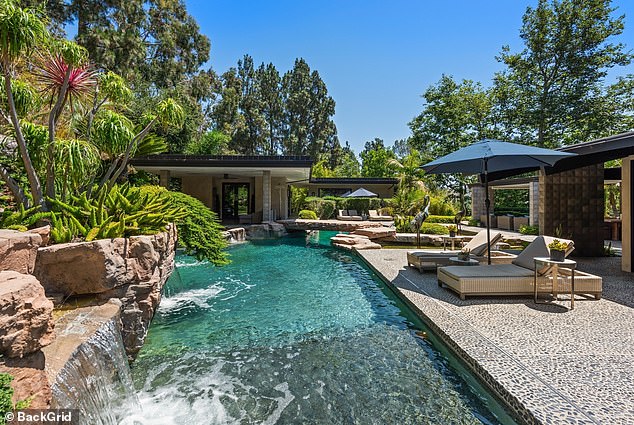 The backyard also features a resort-style pool with lush waterfalls, perfect for hosting gatherings.