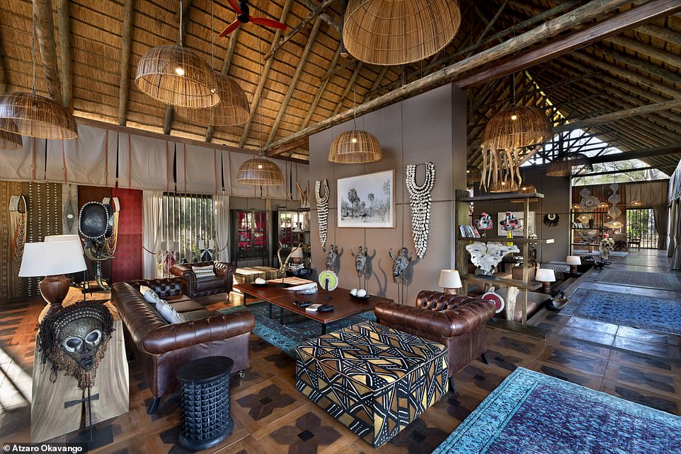 Pictured is the living room, decorated with mid-century furniture and located under a thatched roof.