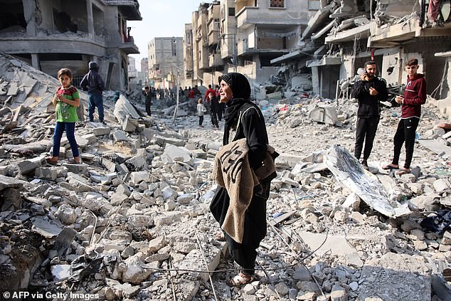 Palestinians walk amid the destruction following an Israeli attack in Jabalia, northern Gaza Strip, on November 10, 2024.