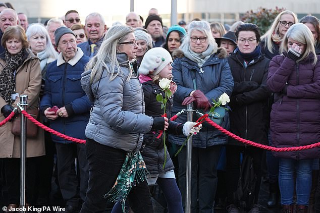 The public lay flowers during a memorial service to mark today's tragedy.